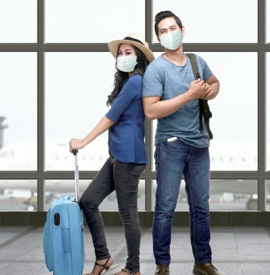 asian-couple-face-mask-with-suitcase-bag-backpack-standing-airport-terminal-traveling-new-normal-1-530x600